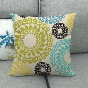 Linen pillow cover with geometric spiral pattern on a dark grey sofa in Nordic style