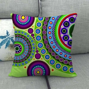 Linen pillowcase with vibrant geometric mandala pattern on a modern grey sofa