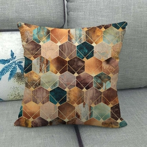 Close-up of geometric marble pattern cushion cover on a grey sofa in home setting