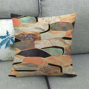 Modern geometric linen pillowcase with marble pattern and gold foil lines on grey sofa