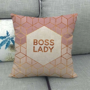 Pink Boss Lady pillow case with gold marble geometric patterns on a grey sofa