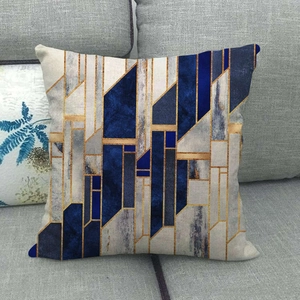 Detailed texture of blue and gold geometric linen cushion cover on a grey fabric sofa