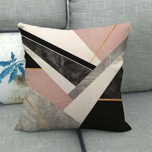 Close-up of geometric marble pattern cushion cover on a grey fabric sofa at home