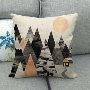 Detail of linen pillowcase featuring abstract marble landscape art on a grey sofa