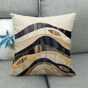 Detail of linen pillowcase with gold and black marble abstract pattern on grey sofa