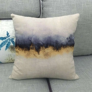 Modern linen throw pillow cover featuring abstract blue and gold marble landscape on a sofa