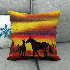 Linen square throw pillow cover featuring a sunset horse silhouette on a gray sofa