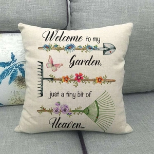 Detailed garden themed linen pillowcase showing floral prints and scripted text on sofa