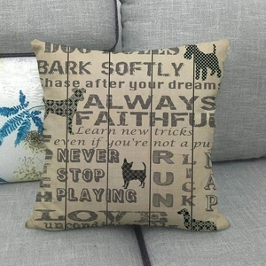 Close-up of linen pillowcase with retro wood grain print and dog silhouettes on sofa