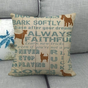 Linen pillow cover with dog silhouettes and faithful quotes on a grey fabric sofa