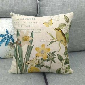 Détail du coussin en lin montrant des motifs floraux et une typographie botanique rétro