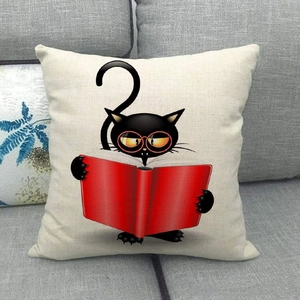 Close-up of a cartoon black cat with red glasses reading on a beige linen pillowcase