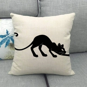 Close-up of a minimalist black cat silhouette printed on a beige linen cushion cover
