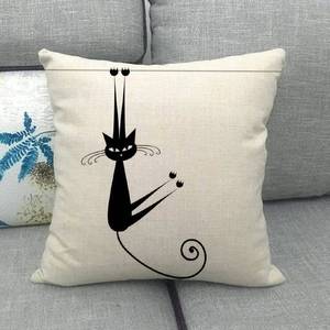 Close-up of minimalist cartoon cat print on a natural linen square pillowcase on sofa