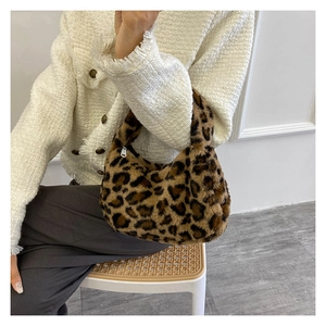 Close-up of leopard print plush shoulder bag styled with a white tweed jacket