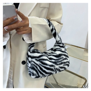 Close-up of zebra pattern plush tote bag styled with an elegant cream-colored suit