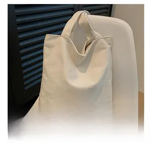 Detail of white canvas tote bag with colorful STUFF embroidery and large capacity design