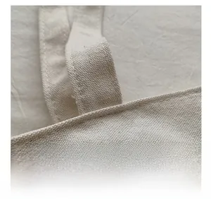 Detail of reinforced double stitching on off-white canvas tote bag handle attachment