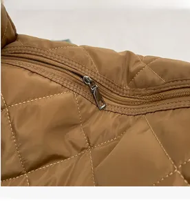 Vue détaillée de la fermeture éclair argentée sur un sac à main matelassé à losanges
