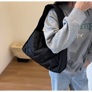 Détail du sac cabas matelassé noir montrant le tissu en nylon léger et vue latérale sur modèle