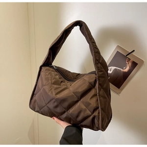 Détail du sac cabas en nylon matelassé marron montrant la texture losange et la bandoulière