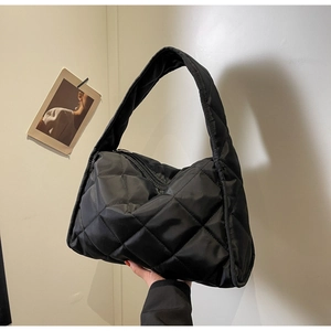 Gros plan sur un grand sac cabas matelassé noir en nylon avec une bandoulière pratique
