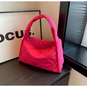 Détail du sac cabas matelassé rouge rose avec motif en losange et fermeture à glissière