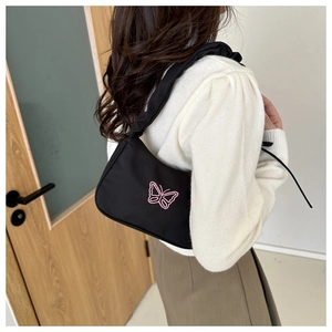 Detail of black nylon underarm bag with pink butterfly embroidery and ruched strap