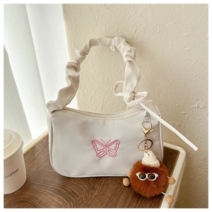 Detail of white crescent bag with pink butterfly embroidery and ruffled handle
