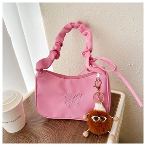 Detail of pink pleated shoulder bag with butterfly embroidery and plush charm decoration