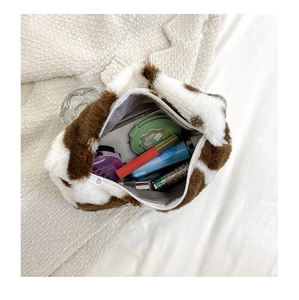 Détail de l'intérieur du sac en peluche vache montrant la capacité pour le maquillage