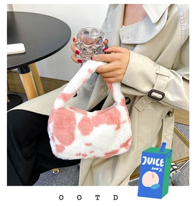 Détail de la texture peluche à motif vache rose et blanc sur ce petit sac à main doux