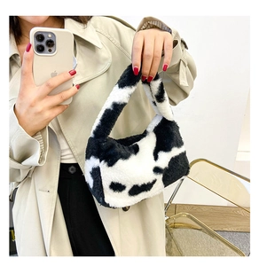 Détail d'un sac à main en peluche à motif vache avec texture douce et anse courbée