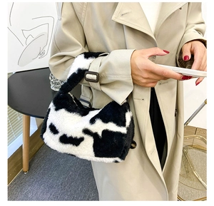 Détail du sac à main en peluche à motif vache porté avec un trench-coat d'automne
