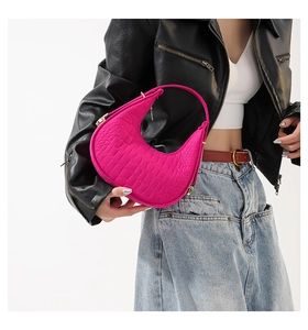 Détail du sac croissant fuchsia avec motif crocodile embossé et fermeture éclair en métal