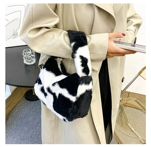 Gros plan du sac à main en peluche imprimé vache avec texture douce en fausse fourrure