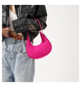 Gros plan du sac hobo rose vif en similicuir avec détails de texture crocodile