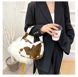 Détail du sac à main en peluche à motif vache avec texture en fausse fourrure douce
