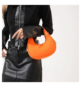 Détail de la texture crocodile orange vif sur un sac à main hobo élégant pour femmes