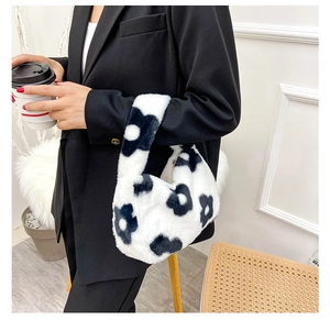 Détail d'un sac à main en peluche avec motif marguerite noir et blanc et texture douce
