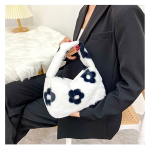 Détail d'un sac à main en peluche duveteux avec imprimé floral noir sur fond blanc