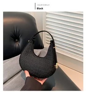 Détail macro du sac sous les aisselles à motif crocodile noir avec boucle dorée