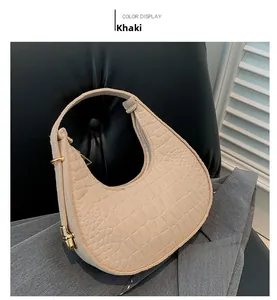 Détail du sac croissant en feutre kaki avec motif crocodile et boucles dorées