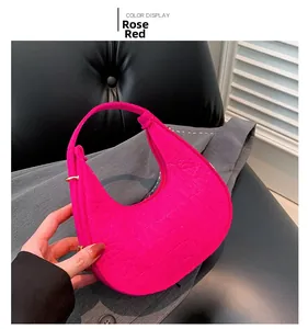 Détail du sac demi-lune rose rouge avec texture crocodile et boucle dorée en métal