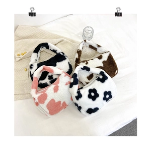 Détail de sacs à main en peluche fausse fourrure aux motifs vache et fleurs