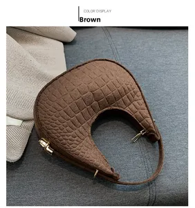 Gros plan du sac croissant marron avec motif crocodile et fermeture éclair dorée