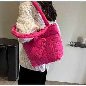 Detail of quilted hot pink puffer tote bag with detachable small matching pouch on shoulder