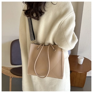 Dettaglio borsa shopper trapuntata con tracolla pied-de-poule e manici a coulisse beige