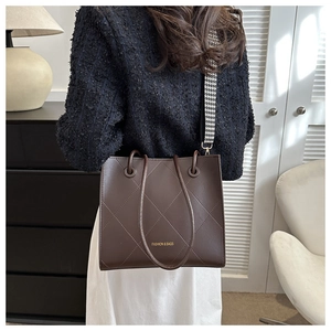 Dettaglio borsa tote marrone vintage con trapuntatura e tracolla a pied-de-poule