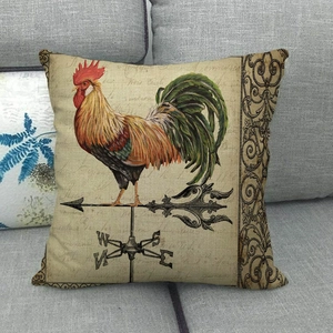 Dettaglio della federa per cuscino in lino con stampa di gallo su divano grigio